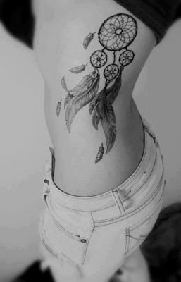  Tatouage attrape rêve avec des plumes qui s'envolent sur le haut des côtes